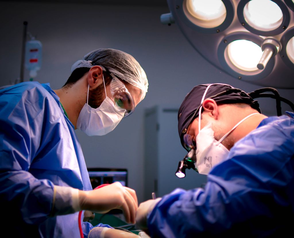 Masked surgeons at work in an operating room