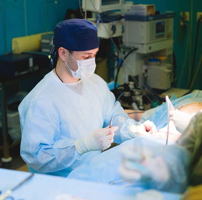 A masked surgeon at work in the operating room